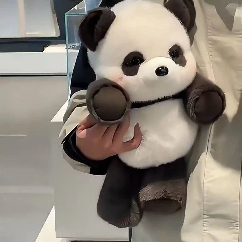 Person holding a plush panda toy in an indoor setting