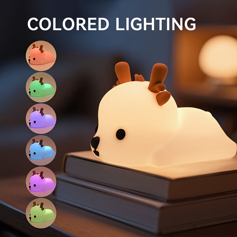 Deer-shaped night light with colored lighting options displayed on a book